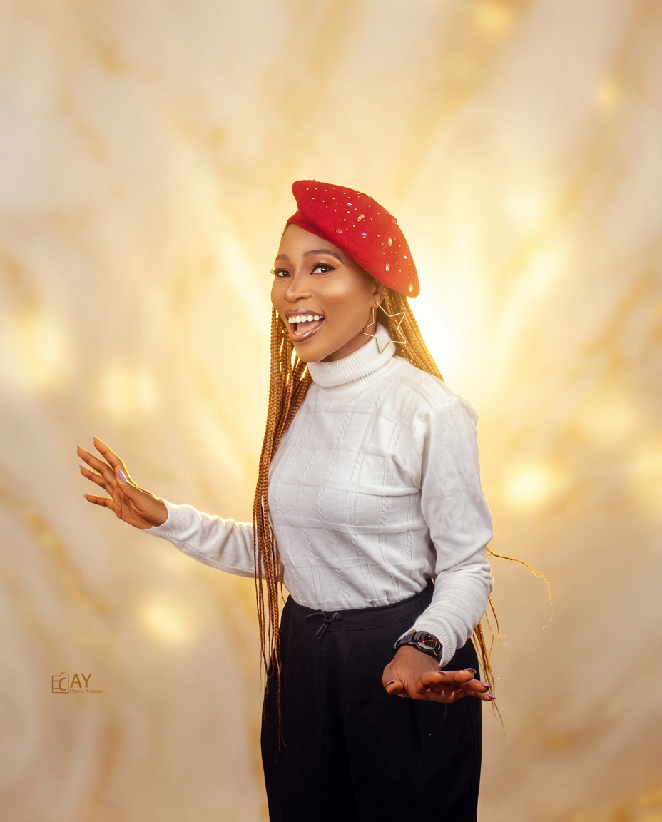 Dharmie smiling brightly in a red beret and white knit top
